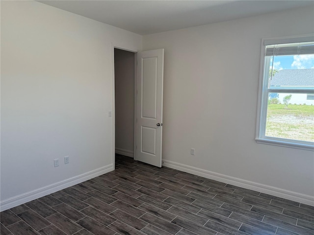 25126 Calusa Dr, Punta Gorda, FL 33955 - unfurnished room featuring a healthy amount of sunlight, baseboards, and dark wood-style floors