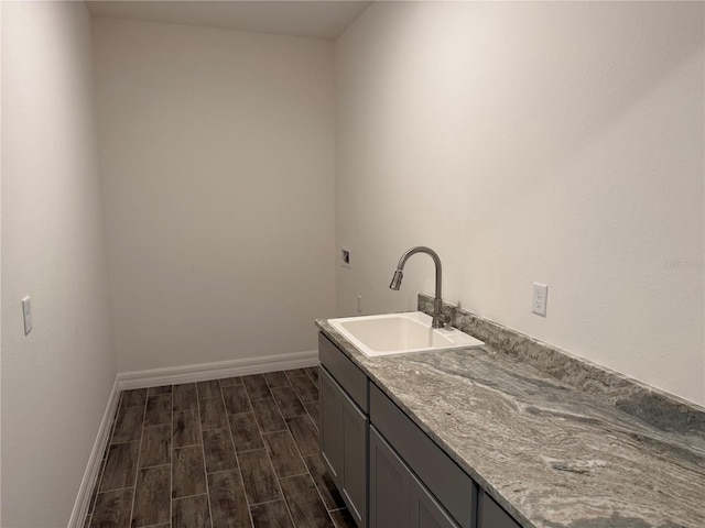 25126 Calusa Dr, Punta Gorda, FL 33955 - laundry room featuring baseboards, dark wood-style flooring, a sink, and cabinet space