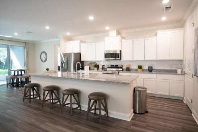 25126 Calusa Dr, Punta Gorda, FL 33955 - kitchen with visible vents, ornamental molding, appliances with stainless steel finishes, a kitchen breakfast bar, and an island with sink