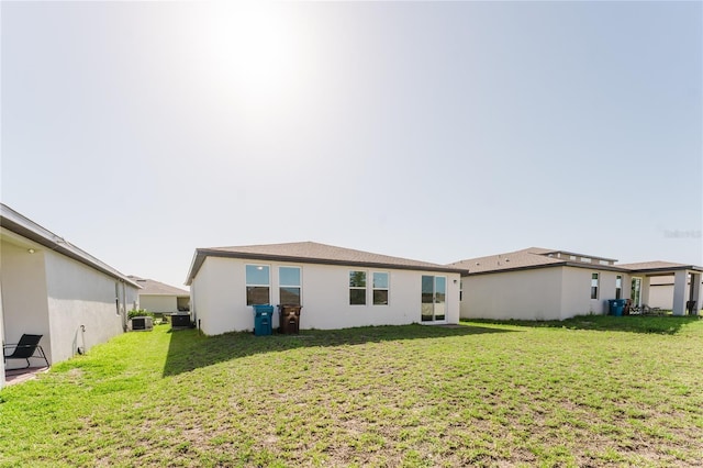 349 Guadlupe St, Haines City, FL 33844 - rear view of house with cooling unit, stucco siding, and a lawn