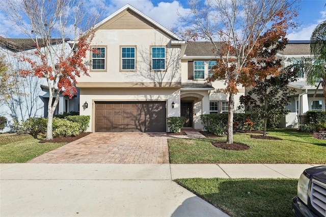 611 Marsh Reed Dr, Winter Garden, FL 34787 - view of front facade with a front yard, a garage, decorative driveway, and stucco siding