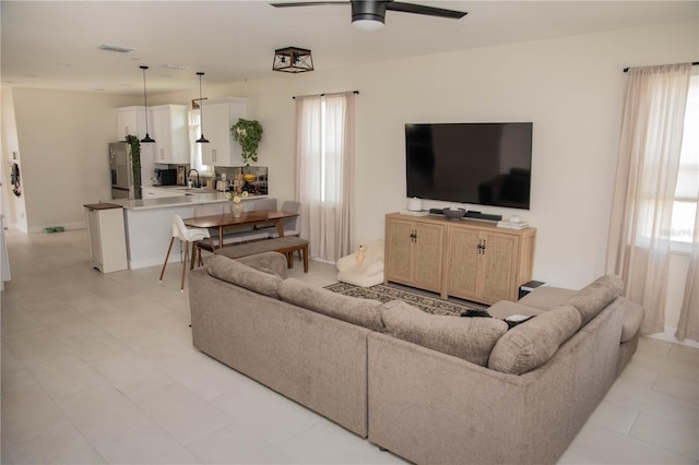 living room featuring a ceiling fan and visible vents