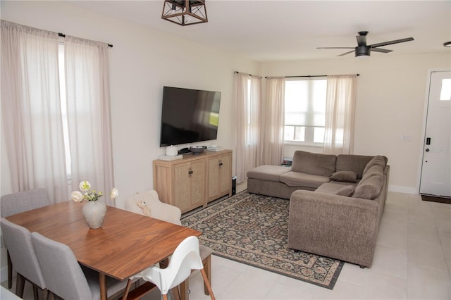 living area featuring a ceiling fan and baseboards