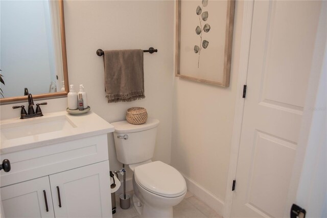 bathroom with toilet, tile patterned flooring, vanity, and baseboards