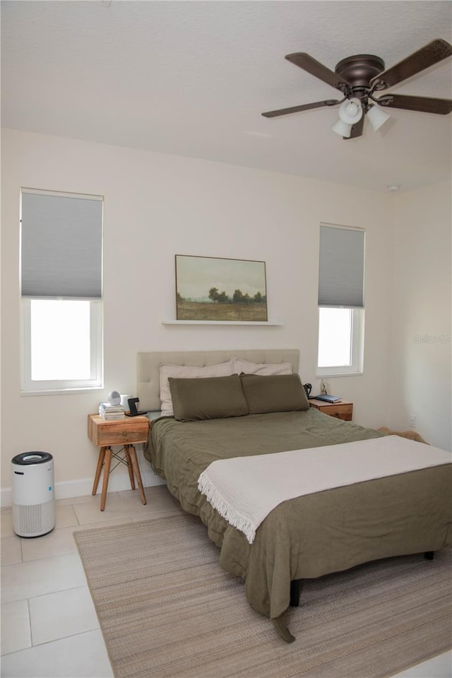 bedroom with a ceiling fan, baseboards, and tile patterned flooring
