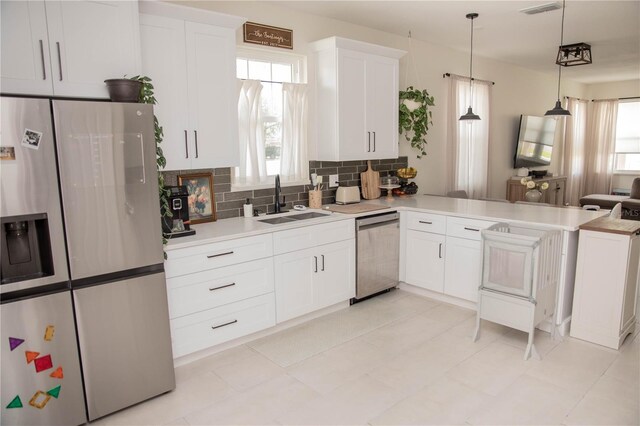 900 S Maple Ave, Sanford, FL 32771 - kitchen with appliances with stainless steel finishes, a sink, tasteful backsplash, white cabinets, and light countertops