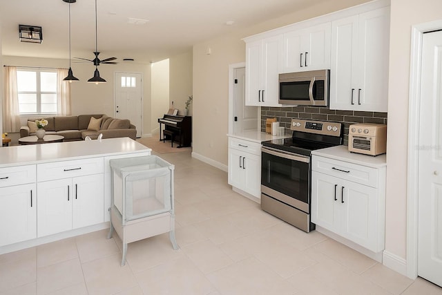 900 S Maple Ave, Sanford, FL 32771 - kitchen featuring appliances with stainless steel finishes, open floor plan, light countertops, backsplash, and white cabinets