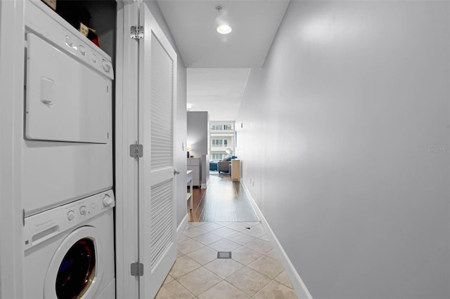 101 S Eola Dr Unit 1018, Orlando, FL 32801 - washroom featuring baseboards, light tile patterned floors, stacked washer and dryer, and laundry area