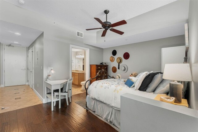 101 S Eola Dr Unit 1018, Orlando, FL 32801 - bedroom featuring visible vents, baseboards, ensuite bathroom, ceiling fan, and wood finished floors