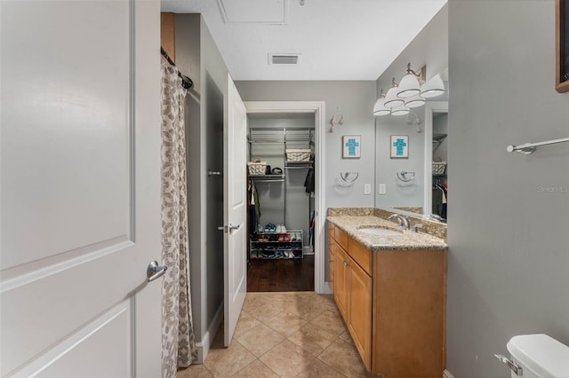 101 S Eola Dr Unit 1018, Orlando, FL 32801 - full bath featuring baseboards, toilet, a spacious closet, vanity, and tile patterned floors