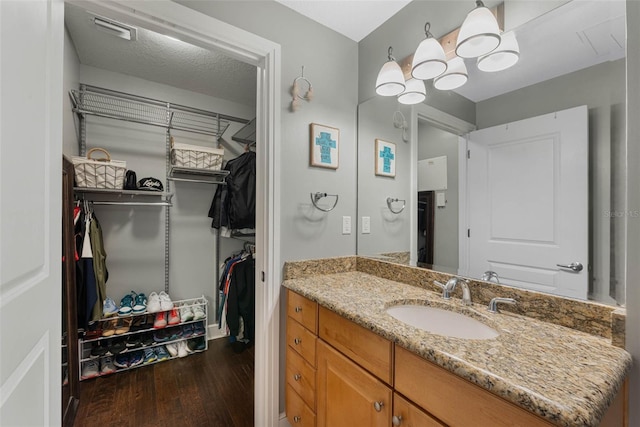 101 S Eola Dr Unit 1018, Orlando, FL 32801 - bathroom featuring wood finished floors, vanity, a spacious closet, and visible vents
