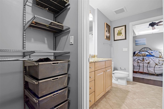 101 S Eola Dr Unit 1018, Orlando, FL 32801 - ensuite bathroom featuring vanity, a ceiling fan, visible vents, toilet, and tile patterned floors