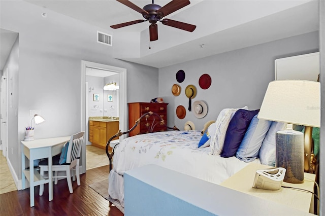 101 S Eola Dr Unit 1018, Orlando, FL 32801 - bedroom featuring ensuite bath, visible vents, a ceiling fan, and wood finished floors