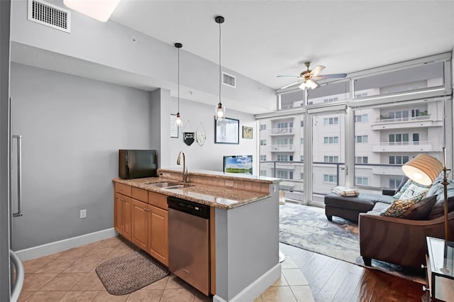 101 S Eola Dr Unit 1018, Orlando, FL 32801 - kitchen with visible vents, a sink, ceiling fan, stainless steel dishwasher, and light stone counters