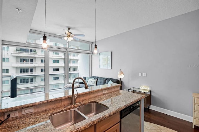 101 S Eola Dr Unit 1018, Orlando, FL 32801 - kitchen featuring light stone countertops, ceiling fan, dishwasher, a sink, and hanging light fixtures