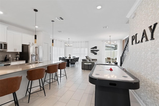 2400 Reading Trl, Kissimmee, FL 34746 - rec room featuring visible vents, a chandelier, wallpapered walls, and light tile patterned floors