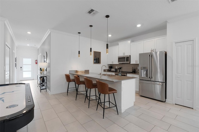 2400 Reading Trl, Kissimmee, FL 34746 - kitchen with a sink, a breakfast bar, backsplash, appliances with stainless steel finishes, and visible vents