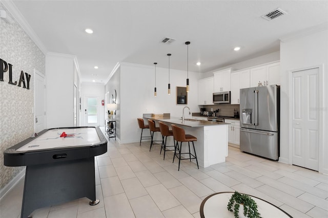 2400 Reading Trl, Kissimmee, FL 34746 - kitchen featuring crown molding, an island with sink, stainless steel appliances, and visible vents