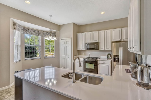 kitchen with a sink, gas range, black microwave, light countertops, and decorative light fixtures