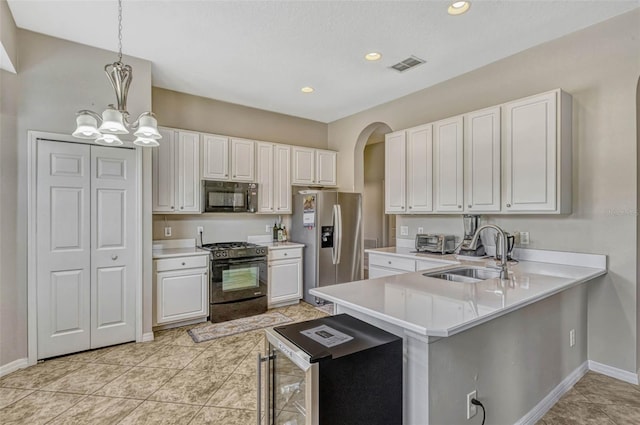 kitchen with black appliances, baseboards, a sink, and visible vents