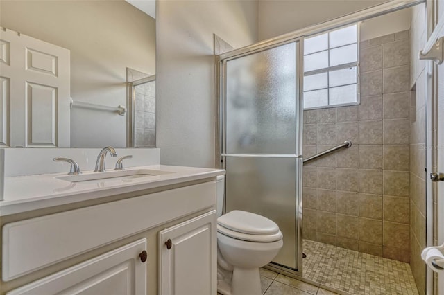 full bathroom featuring vanity, tile patterned flooring, tiled shower, and toilet