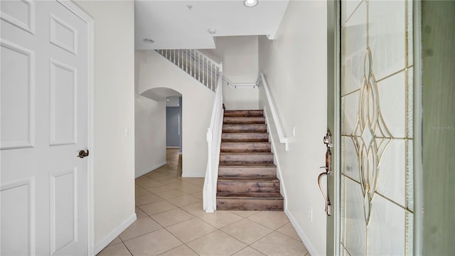 2167 Velvet Leaf Dr, Ocoee, FL 34761 - foyer entrance featuring arched walkways, light tile patterned floors, baseboards, and stairs