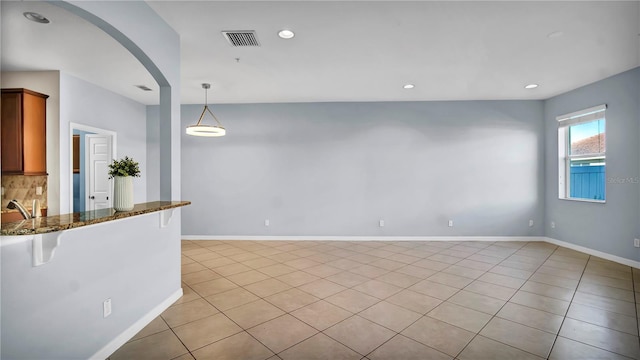 2167 Velvet Leaf Dr, Ocoee, FL 34761 - interior space featuring dark stone counters, light tile patterned floors, visible vents, recessed lighting, and a breakfast bar area