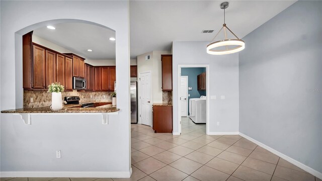 2167 Velvet Leaf Dr, Ocoee, FL 34761 - kitchen with arched walkways, visible vents, dark stone countertops, stainless steel appliances, and decorative backsplash