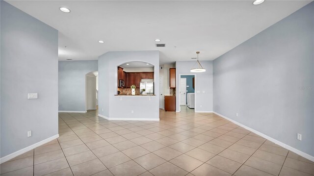 2167 Velvet Leaf Dr, Ocoee, FL 34761 - unfurnished living room with visible vents, baseboards, light tile patterned floors, arched walkways, and recessed lighting