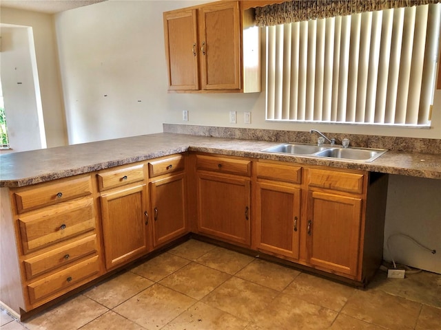 1805 San Luis Ln, The Villages, FL 32159 - kitchen featuring a sink, a peninsula, brown cabinets, and light tile patterned floors