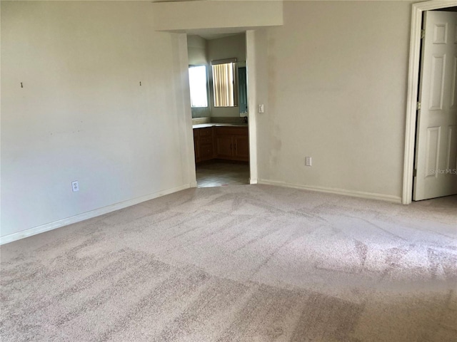 1805 San Luis Ln, The Villages, FL 32159 - unfurnished bedroom with light colored carpet, baseboards, and connected bathroom