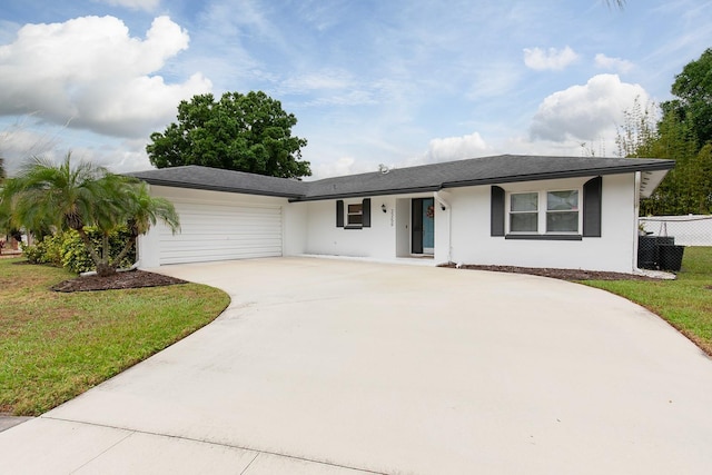 single story home with stucco siding, a front yard, fence, an attached garage, and concrete driveway