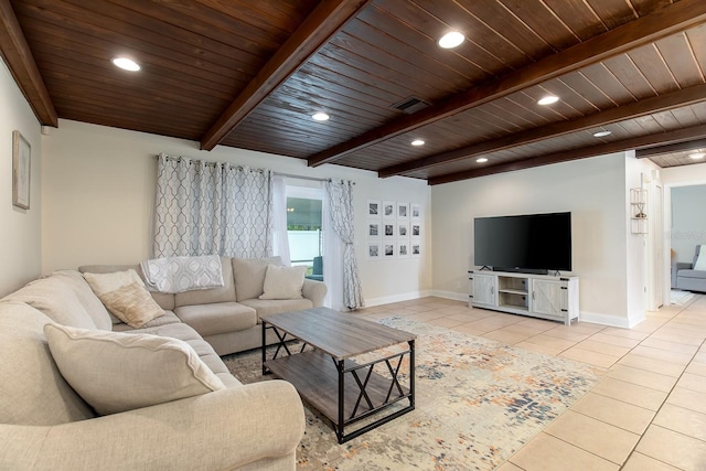 living room with visible vents, baseboards, beamed ceiling, and light tile patterned flooring