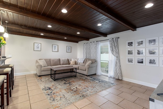 living room with light tile patterned floors, baseboards, wooden ceiling, and beam ceiling