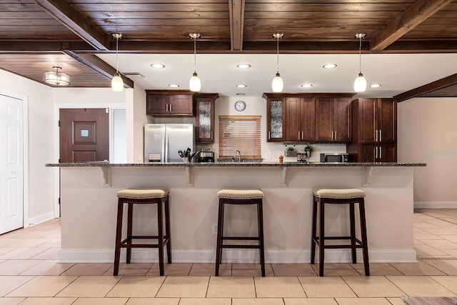 kitchen featuring a breakfast bar area, stainless steel appliances, and wood ceiling