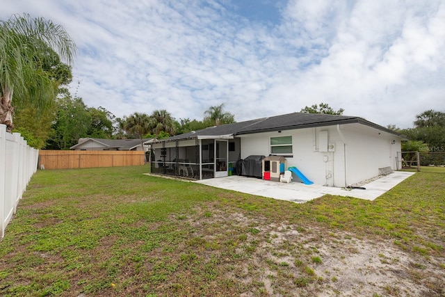 rear view of property with a yard, a fenced backyard, a patio, and a sunroom