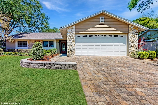 7845 Clubhouse Estates Dr, Orlando, FL 32819 - single story home with decorative driveway, stone siding, a front yard, and a garage