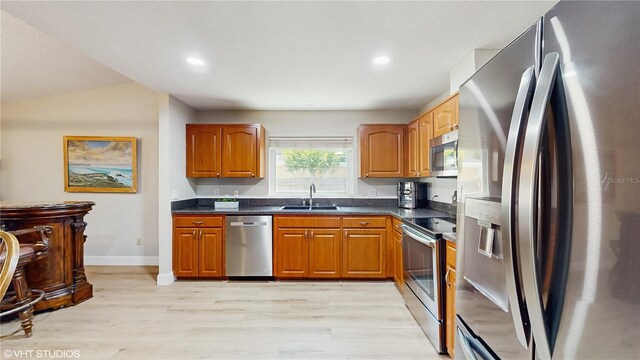 7845 Clubhouse Estates Dr, Orlando, FL 32819 - kitchen with brown cabinetry, appliances with stainless steel finishes, a sink, and light wood finished floors