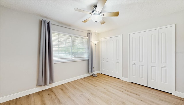 7845 Clubhouse Estates Dr, Orlando, FL 32819 - unfurnished bedroom with two closets, baseboards, a ceiling fan, and light wood-style flooring