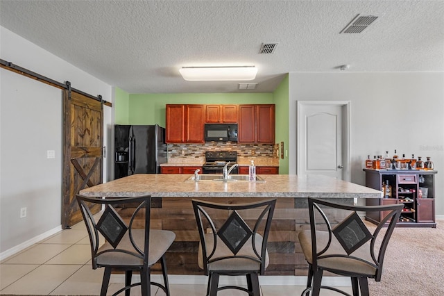 1918 Marabou Dr, Davenport, FL 33896 - kitchen with light countertops, visible vents, a kitchen breakfast bar, and black appliances