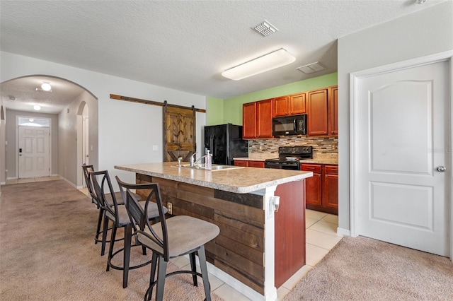 1918 Marabou Dr, Davenport, FL 33896 - kitchen with light carpet, arched walkways, visible vents, light countertops, and black appliances
