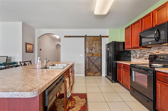 1918 Marabou Dr, Davenport, FL 33896 - kitchen with a barn door, a sink, black appliances, arched walkways, and backsplash