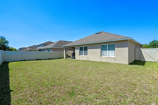 1918 Marabou Dr, Davenport, FL 33896 - rear view of house with a fenced backyard, a gate, a yard, and stucco siding
