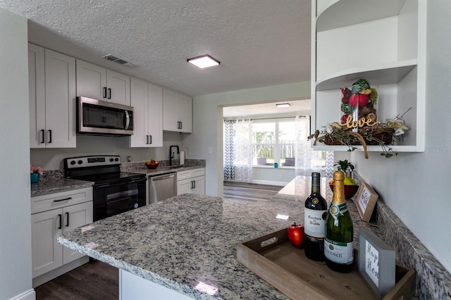 kitchen with dark wood-type flooring, white cabinetry, open shelves, visible vents, and appliances with stainless steel finishes