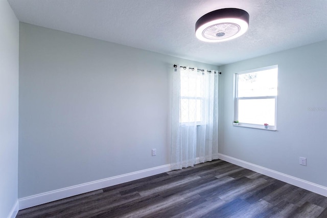 unfurnished room with baseboards, a textured ceiling, and dark wood finished floors