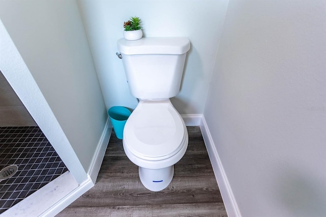 bathroom with toilet, wood finished floors, and baseboards