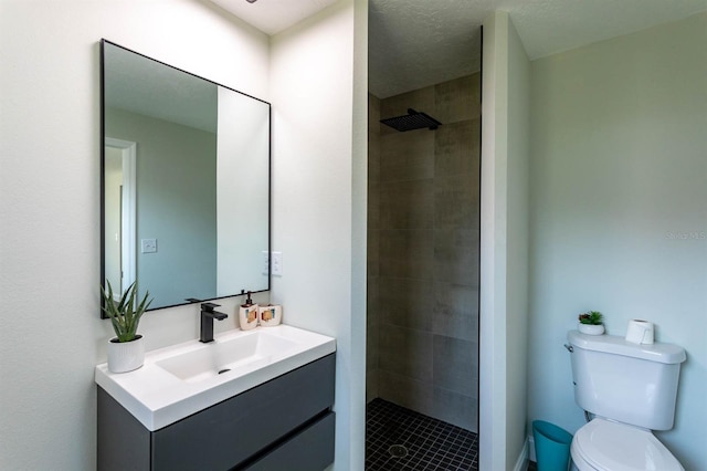bathroom featuring tiled shower, vanity, toilet, and tile patterned flooring