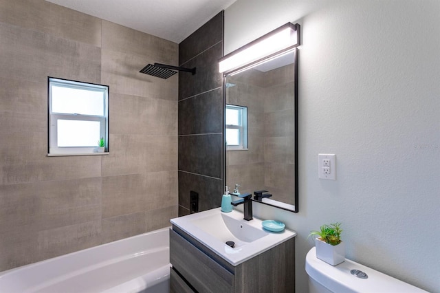 bathroom featuring toilet, vanity, washtub / shower combination, and plenty of natural light