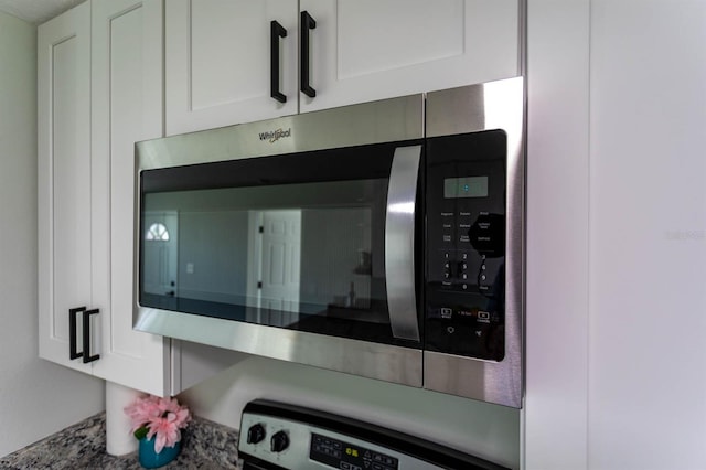 details featuring stainless steel microwave and white cabinets