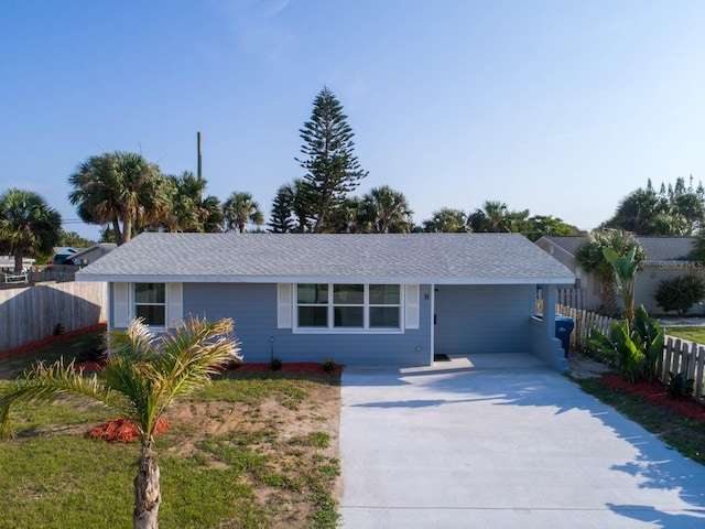 ranch-style home featuring concrete driveway and fence